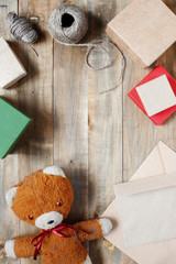 Vintage wooden background with teddy bear, gift boxes and envelopes