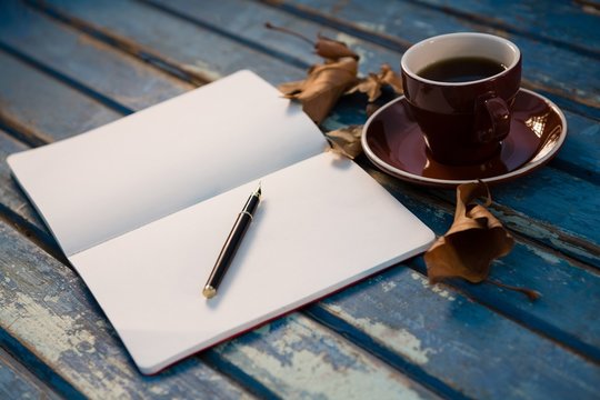 Close Up Of Open Book By Coffee Cup