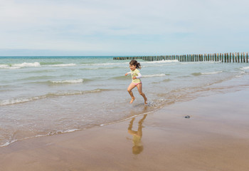 jolie fille tonique courant sur la plage