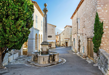 Medieval street with a fountain in the village Gourdon, France