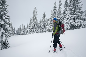 Fototapeta na wymiar Smiling traveler is standing in a deep snow