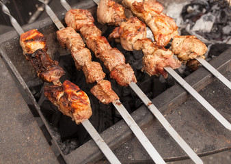 Grilled kebab cooking on metal skewer. Roasted meat cooked at barbecue. BBQ fresh beef meat chop slices. Traditional eastern dish, shish kebab.