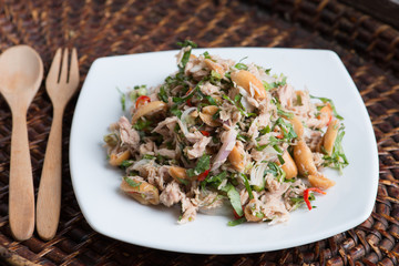 Spicy tuna salad on wood background