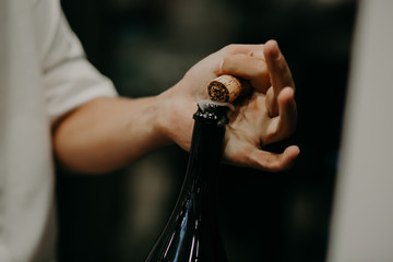 Sommelier opening wine bottle in the wine cellar