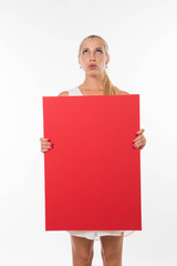 Young pensive woman portrait of a confident businesswoman showing presentation, pointing placard gray background. Ideal for banners, registration forms, presentation, landings, presenting concept.