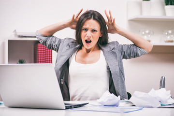 Young businesswoman is angry because she is tired of work. 
