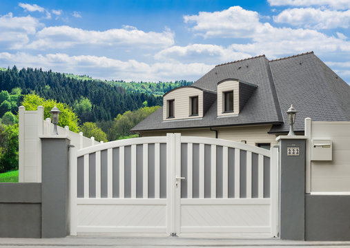 Modernes PVC-Gartentor in grau und wei&szlig; und Einfamilienhaus in sch&ouml;ner Landschaft - Modern PVC garden door and family home in beautiful landscape