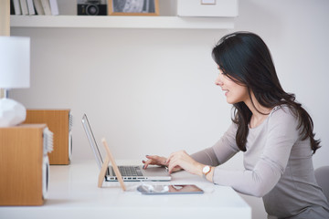 Caucasian woman sitting and working at home office