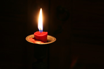 burning candle in old tin candle stick