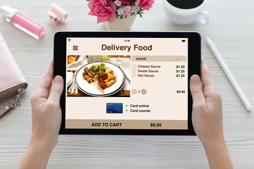 woman hands holding tablet computer with app delivery food screen