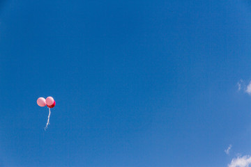 Three balloons fly in blue sky