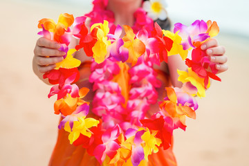 Beautiful floral Hawaiian Lei in the hands of a close-up woman © kosmos111