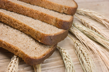 slices of rye bread and ears of corn on the wooden table