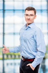 Male successful young businessman posing in office