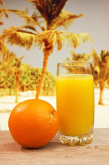 Glass of orange juice on a beach