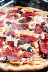 pizza with salami, mushrooms and cheese homemade . shallow depth of field. soft focus