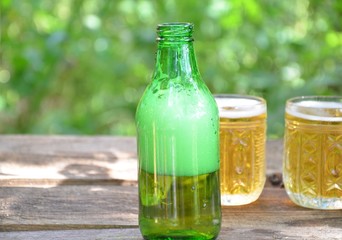 Two Glasses of cider or light beer and bottle on rustic wooden background octobcrfest