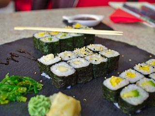 Delicious sushi and chop sticks on restaurant table.