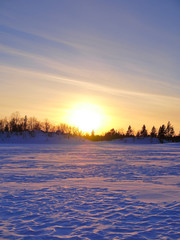 Beautiful sunset over snow covered frozen lake. Winter backgrounds.