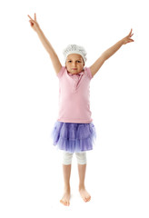 Little girl in pink shirt and purple skirt lifts hands up on white