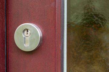 A metal keyhole on brown wooden door
