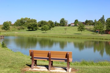Fototapeta na wymiar The empty wood bench at the lake.
