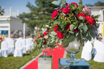 Fototapeta na wymiar Wedding decor. Wedding registration outdoor. Luxury bouquets with red flowers