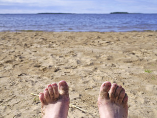 Sandy feet closeup at the beach. Summer background.