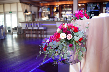 Fototapeta na wymiar Wedding decor. Red Flowers in the restaurant, table setting