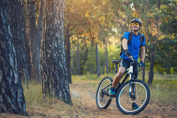 man cyclist rides in the forest on a mountain bike.