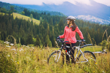 Obraz premium young woman riding a bicycle on the high plateau