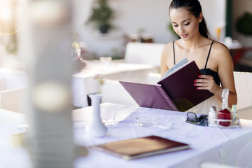 Fototapeta premium Beautiful woman ordering from menu