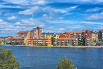 Fototapeta premium KARLSKRONA, SWEDEN - 2017 July. Typical red Swedish wooden houses with natiaonal flag in the city of Karlskrona