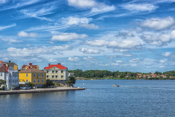 Obraz premium KARLSKRONA, SWEDEN - 2017 July. Typical red Swedish wooden houses with natiaonal flag in the city of Karlskrona