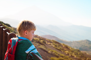 little boy hiking looking at view in mountains