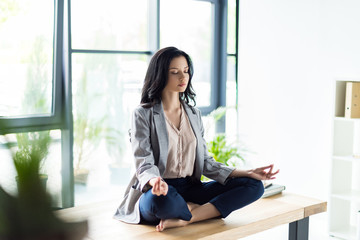 businesswoman meditating at workplace