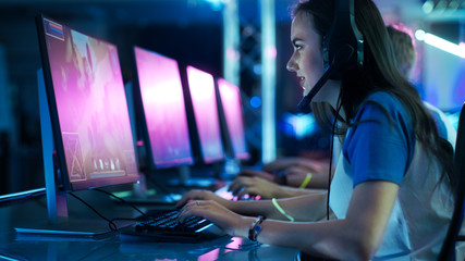 Team of Professional eSport Gamers Playing Competitive  MMORPG/ Strategy Video Game on a Cyber Games Tournament. They Talk to Each other into Microphones. Arena Looks Cool with Neon Lights.