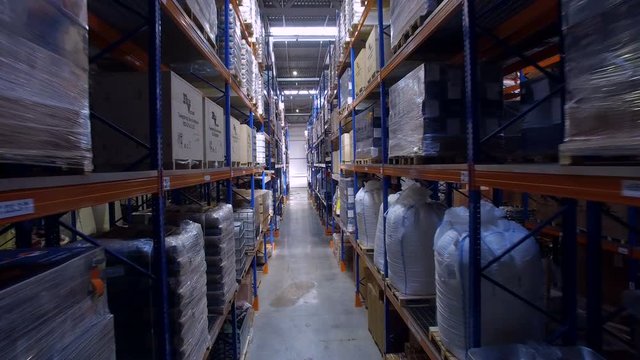 Storage warehouse. Camera cranes goes up on shelves. 4K.