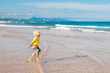 Child on tropical beach. Sea vacation with kids.