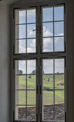 Ancient glass window with panoramic view over green hills