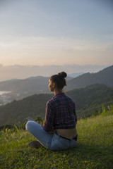 Fototapeta na wymiar Hipster young girl enjoying sunset on peak mountain. Tourist traveler on background valley landscape view mockup.