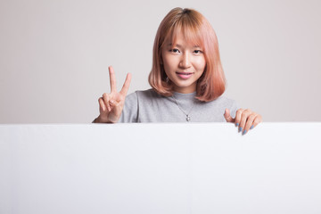 Young Asian woman show victory sign with blank sign.