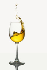 Glass of white wine with splash on white background