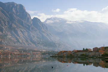 Fototapeta na wymiar Winter day on the coast of Kotor Bay of Adriatic Sea, Montenegro. View of Lovcen mountain, town of Prcanj and town of Dobrota