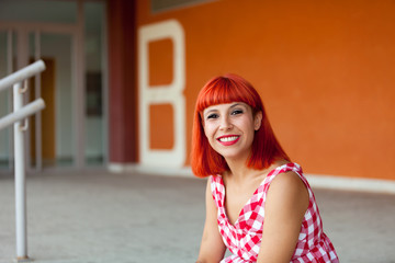 Red haired woman looking at camera in the stree