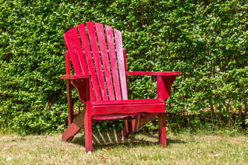 red wooden chair against a green background