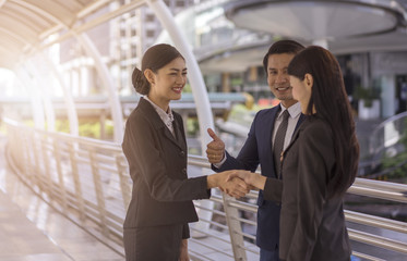 Happy business people concept, Business people shaking hands, finishing up a meeting.