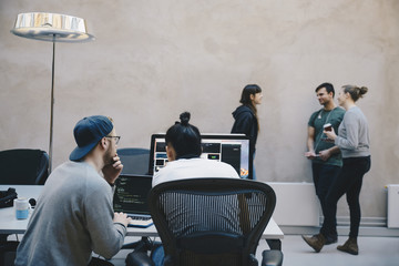 Computer programmers discussing in office