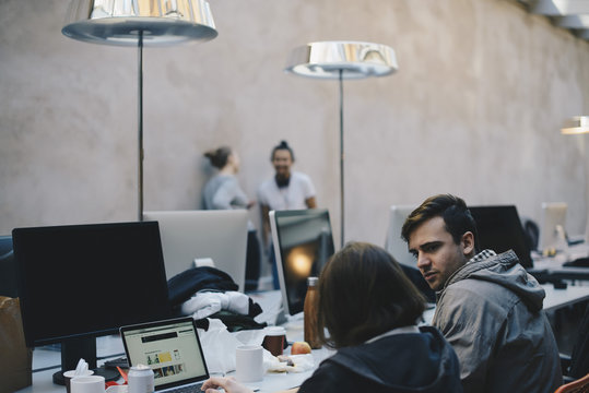 Computer programmers discussing in creative office
