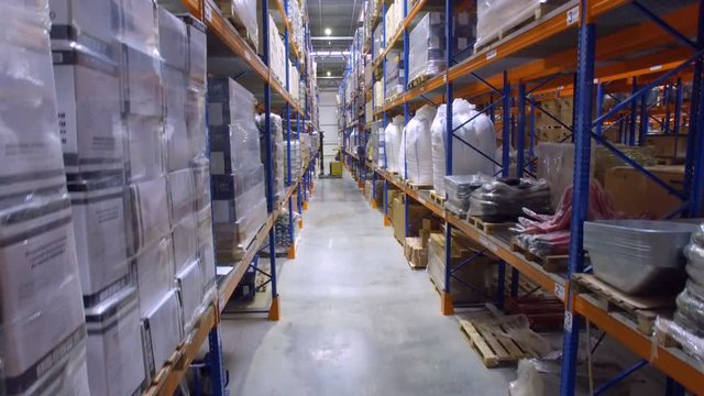 Working forklift loader inside huge industrial Warehouse. Aerial shot.